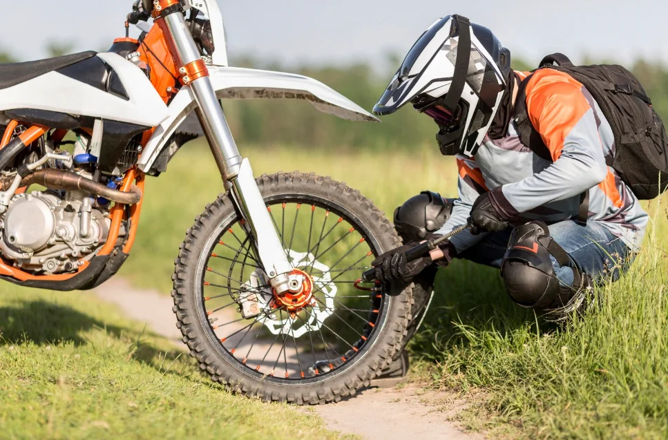 Piloto ajustando moto equipada con guardabarros fibra de carbono para offroad